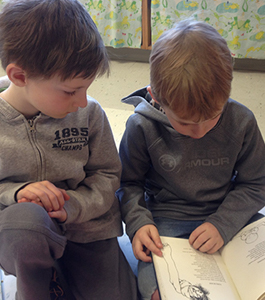 Two boys reading a book together